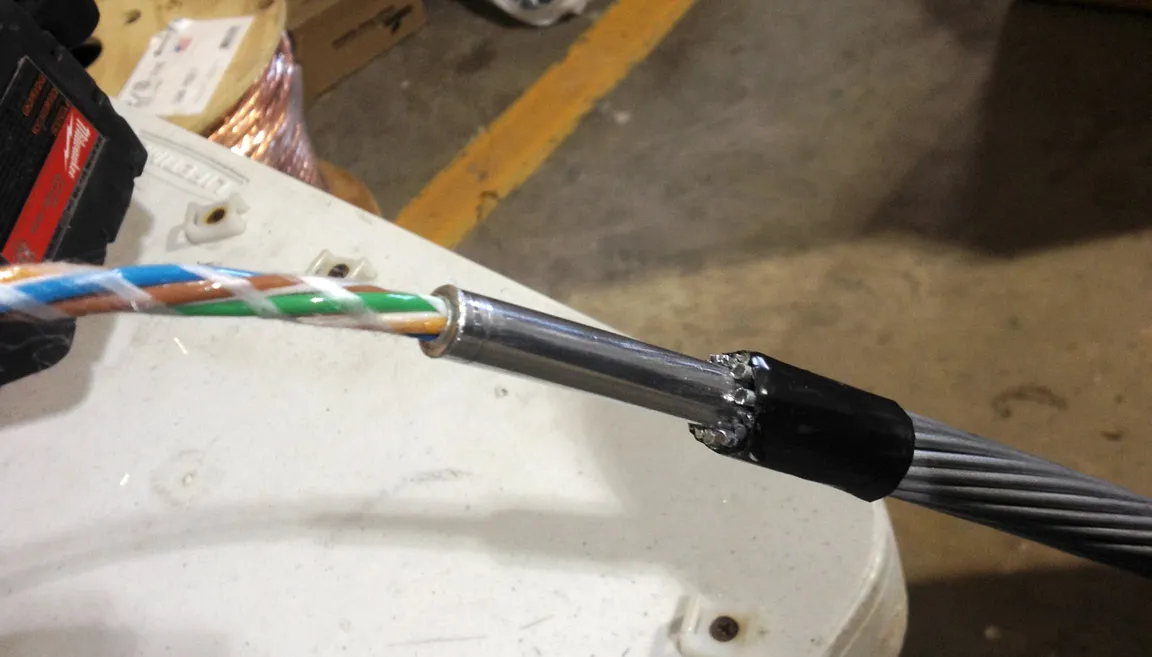 Close-up of a prepared cable splice showing exposed conductors and twisted-pair wiring