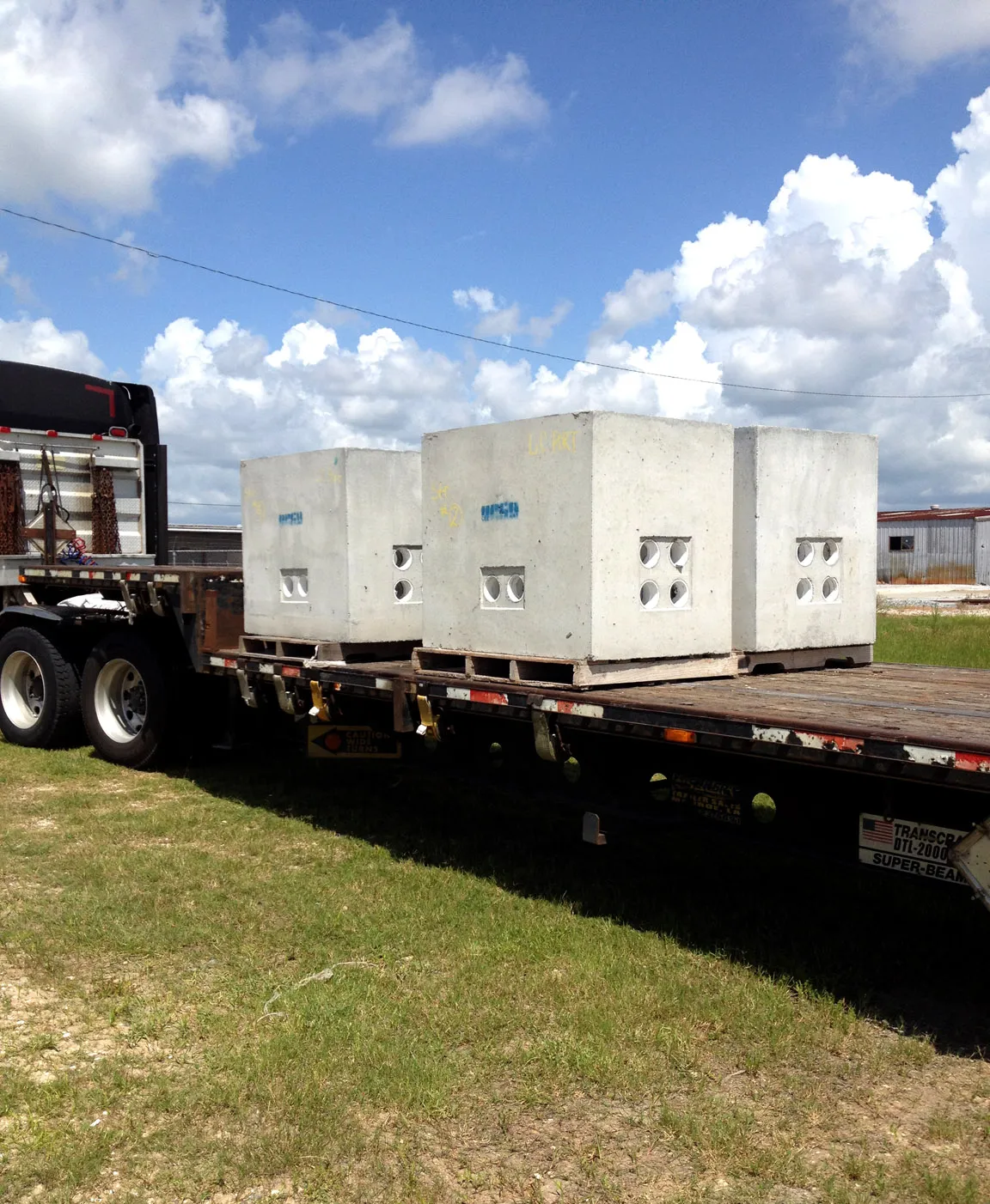 Two precast concrete utility vaults loaded on a flatbed trailer for delivery