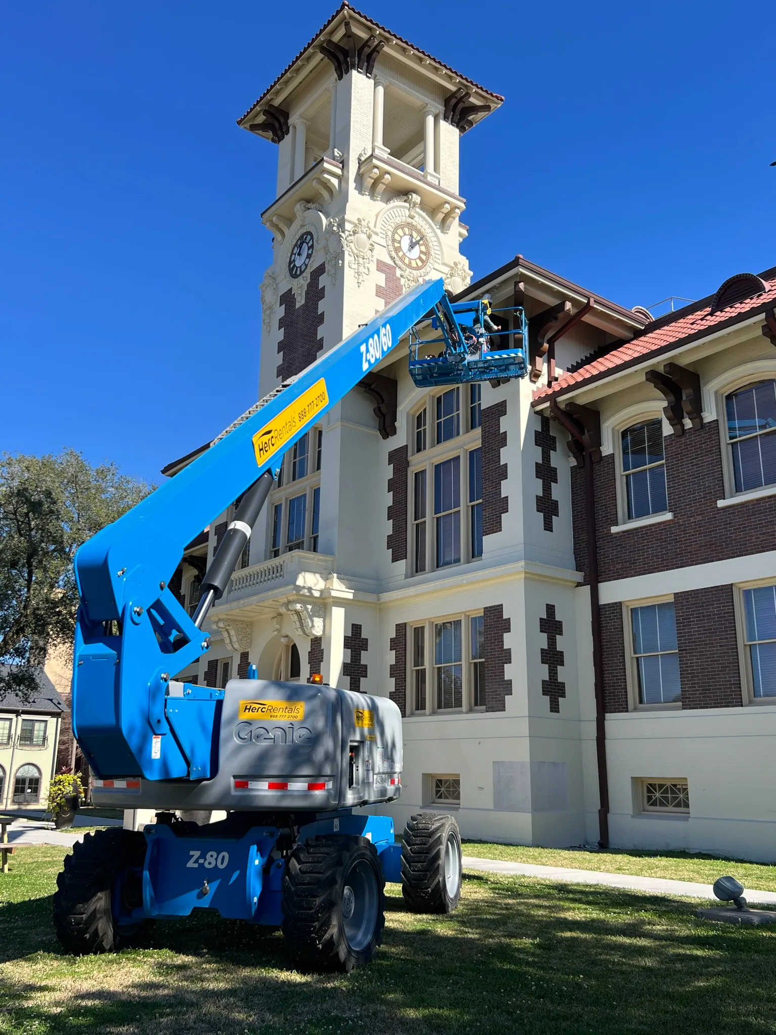 Aerial boom lift raised to the clock tower of the historic old Lake Charles courthouse for cabling work